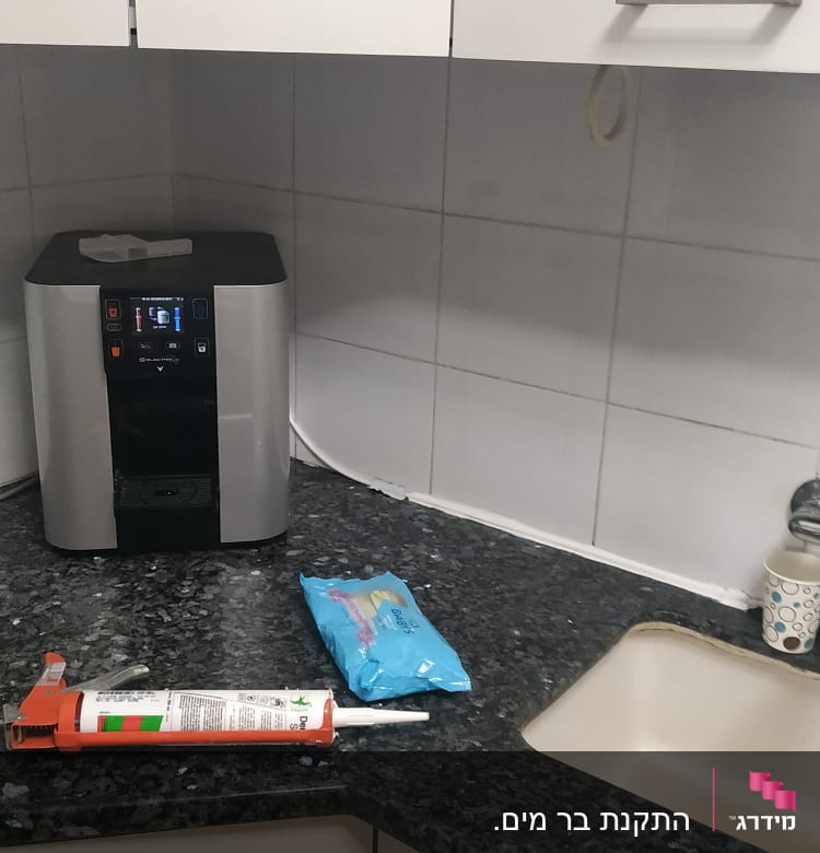 אקדח סיליקון על השיש במטבח